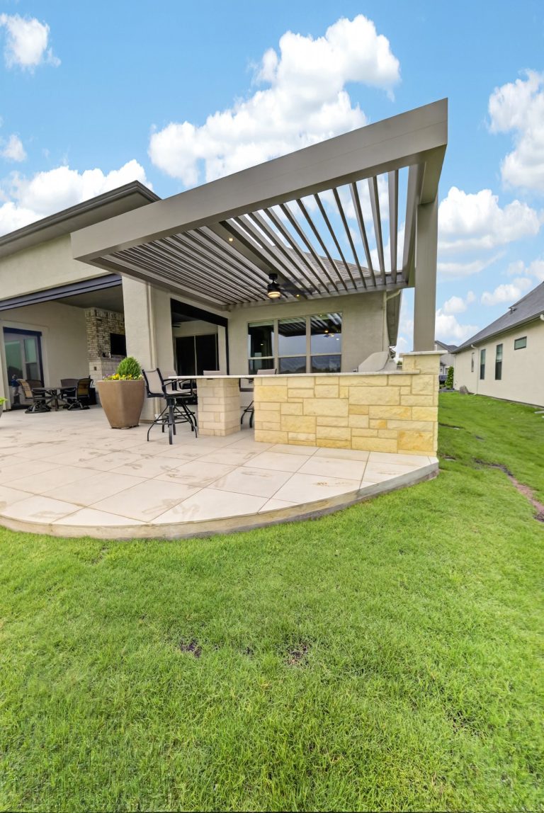 Denton Motorized Louvered Pergola — Ground exterior with louvers open, fan and outdoor kitchen
