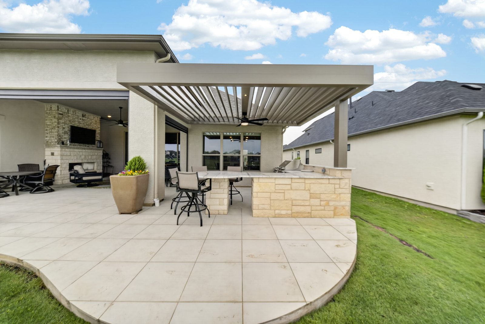Denton motorized pergola — wide exterior with outdoor kitchen and bar seating