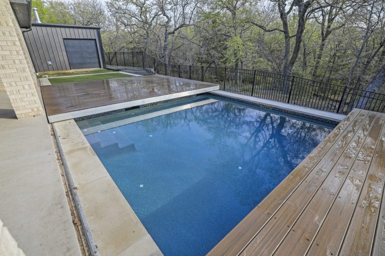 Oak Point pool deck — ground level pool angle with deck half-retracted and iron fence